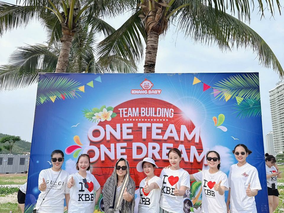 Team cửa hàng chụp cùng backdrop chương trình